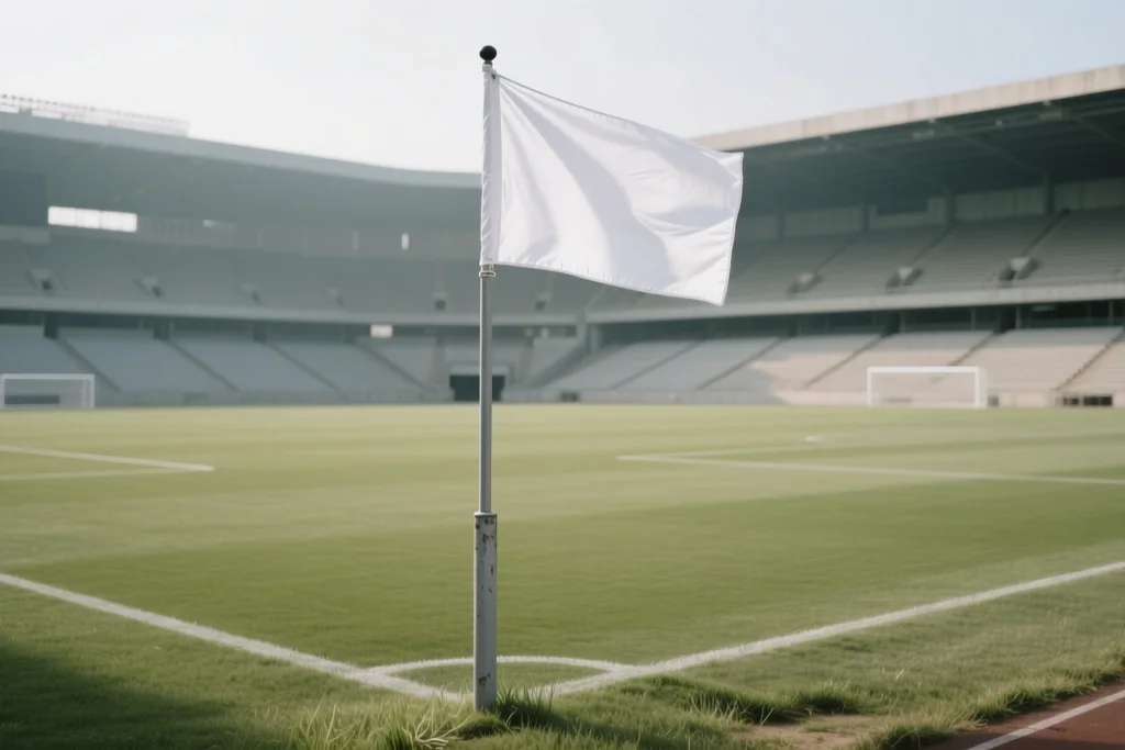 Touchline flag on the grass with the running track and empty stands behind